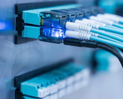 Close-up of fiber optic network cables within a LAN network